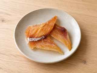 白い器に並べた、自然な厚みと繊維のある真鯛ジャーキー